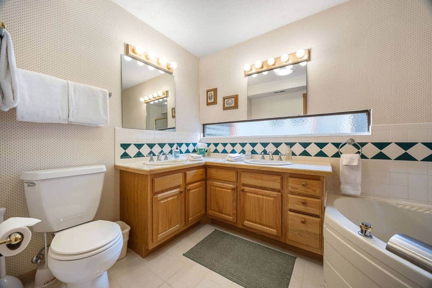 Un baño con inodoro, lavabo, tocador y bañera.