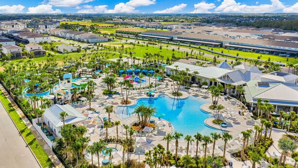 Ein Resort mit mehreren Schwimmbecken, Palmen und einem großen Gebäudekomplex.