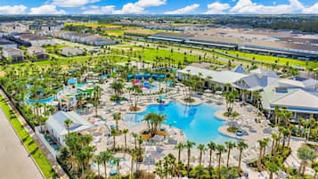 Un complexe hôtelier doté de plusieurs piscines, de palmiers et d’un grand ensemble de bâtiments.