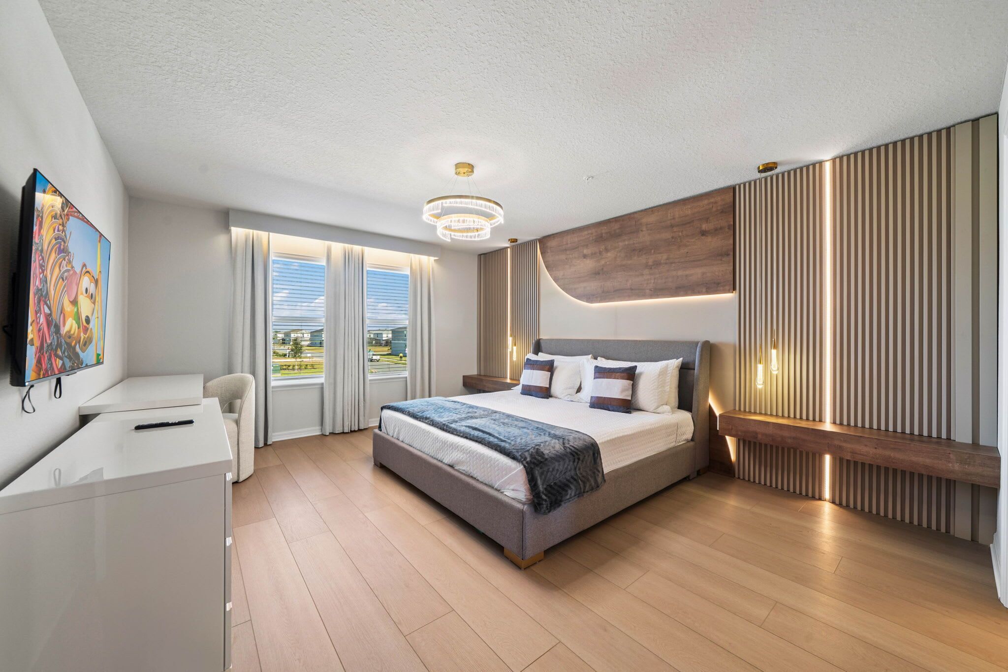 Une chambre moderne avec un grand lit, un bureau et une télévision.