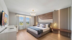 Ein modernes Schlafzimmer mit einem großen Bett, einem Schreibtisch und einem Fernseher.