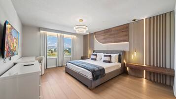 Une chambre moderne avec un grand lit, un bureau et une télévision.
