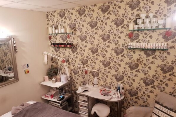 A room with a vanity, mirror, and shelves with toiletries.