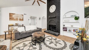 Un salon moderne avec une cheminée, un canapé, une table basse et des objets de décoration.