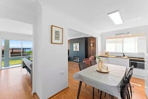 Et moderne interiør med spiseområde, køkken og en balkon med udsigt.