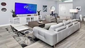 A modern living room with a white sofa, a coffee table, a TV, and a white cabinet. - Phoenix, quite Area, Pool and great water few (Cape Coral)