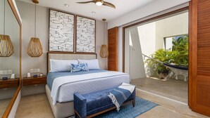 Una camera da letto moderna con un letto grande, una testiera in legno, una ventola a soffitto e vista su un balcone con piante.
