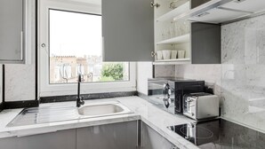 Eine moderne Küche mit integriertem Spülbecken, einem Herd und einem Fenster mit Blick auf eine Stadtlandschaft.