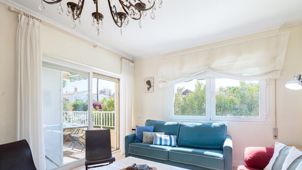 Una sala de estar con sofá, sillón y una mesa con adornos.