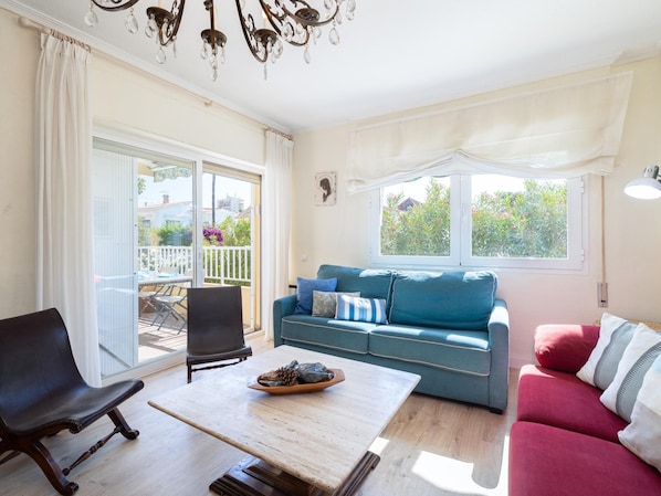 Een woonkamer met een bank, fauteuil en een tafel met decoratieve objecten.