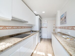 Eine moderne Küche mit weißen Schränken, Granit-Arbeitsplatten und Holzboden.