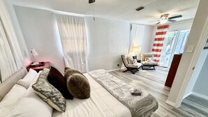 Een moderne slaapkamer met een groot bed, een stoel en uitzicht op het groen.