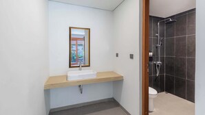 Un bagno moderno con un mobile vanitario in legno, uno specchio grande, una doccia e un water.