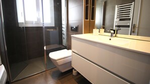 A modern bathroom with a glass-enclosed shower, a toilet, a sink, and a mirror. - CALA FONDA Apartment in Santa Margarita Roses (ROSES)