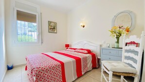 A bedroom with a bed, a chair, a dresser, a mirror, and a window. - CENTRAL Apartment Roses near the beach with sea view (Roses)