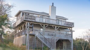 Ein zweigeschossiges Haus mit einem Balkon und einer Treppe, die zu der oberen Etage führt.