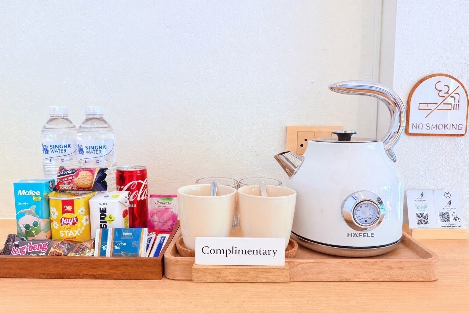 A complimentary tray with snacks, drinks, and a kettle.
