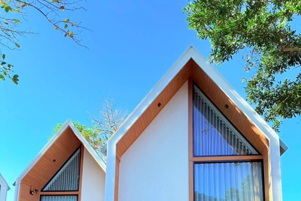 A modern two-story house with large windows and a clear sky.