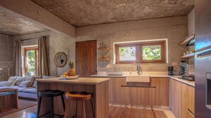 Una cucina moderna con mobili in legno, un'isola centrale con sgabelli, un lavello e una finestra vista verde.
