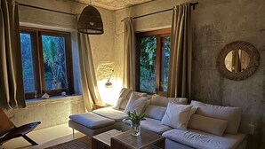 Un soggiorno moderno con un divano componibile, un tavolino in legno e una lampada a sospensione.