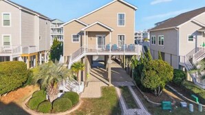 Un quartiere residenziale con diverse case a due piani, una tettoia e giardini curati.