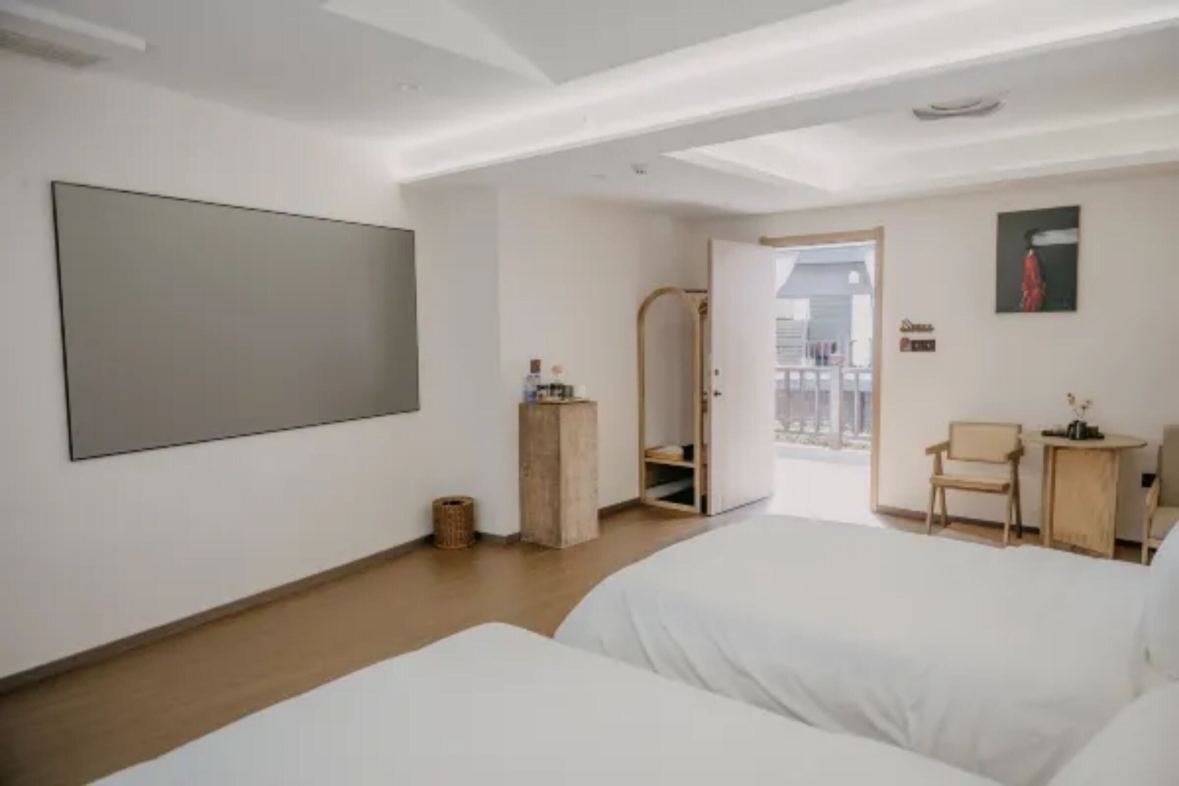 Habitación de hotel con dos camas, un espejo grande, una mesita y una silla.