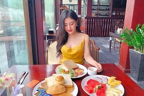 Une table à manger avec de la nourriture et une personne assise à cette table.