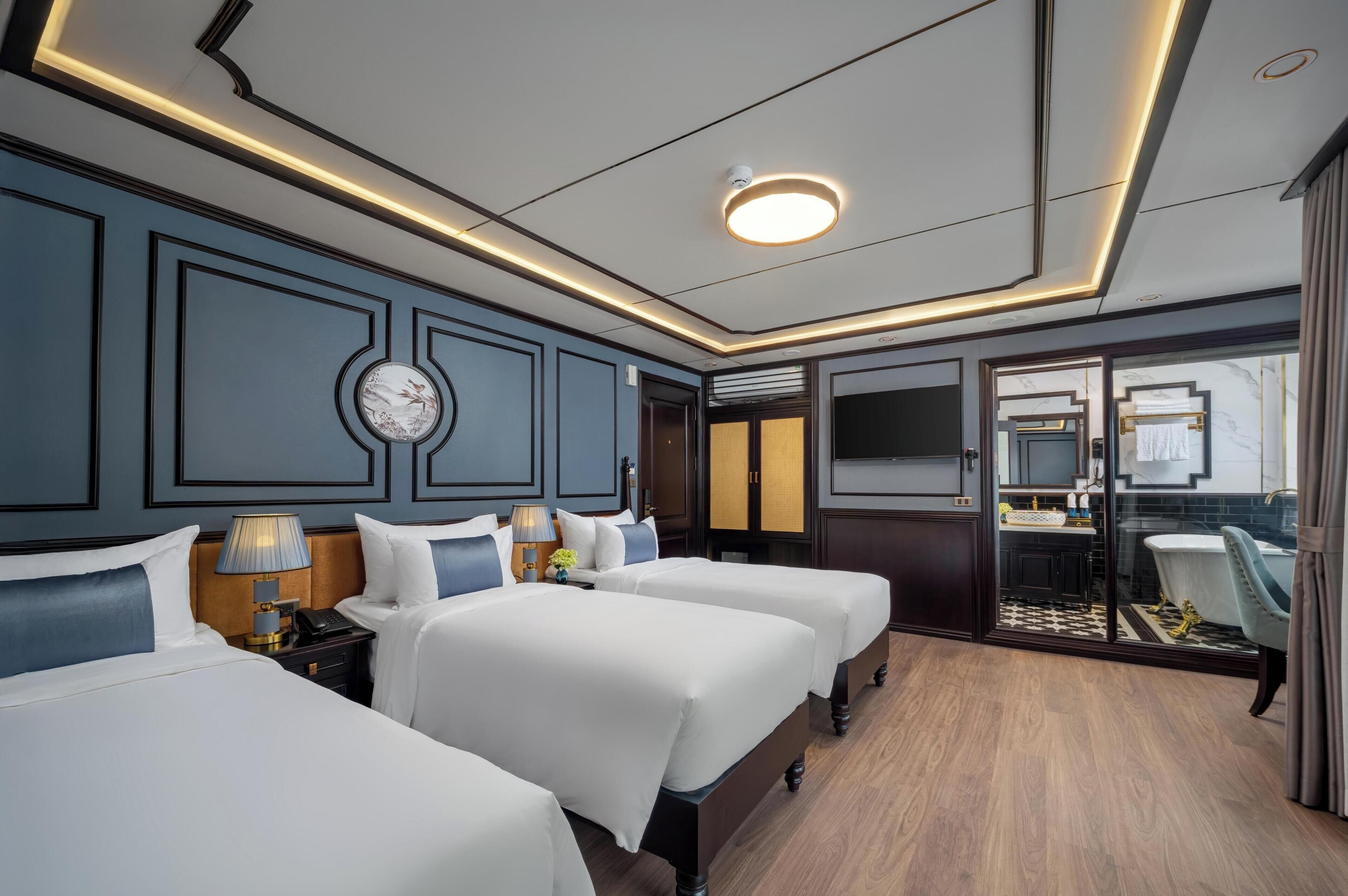 Une chambre d’hôtel avec deux lits, une salle de bain avec un miroir et une vue sur la ville.