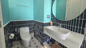 A bathroom with a toilet, sink, and mirror. - Marina Hillside Condotel (An Thoi)