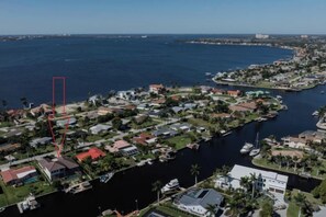 An aerial view of a coastal residential area with houses, a marina, and a body of water. - Villa Skye (Cape Coral)