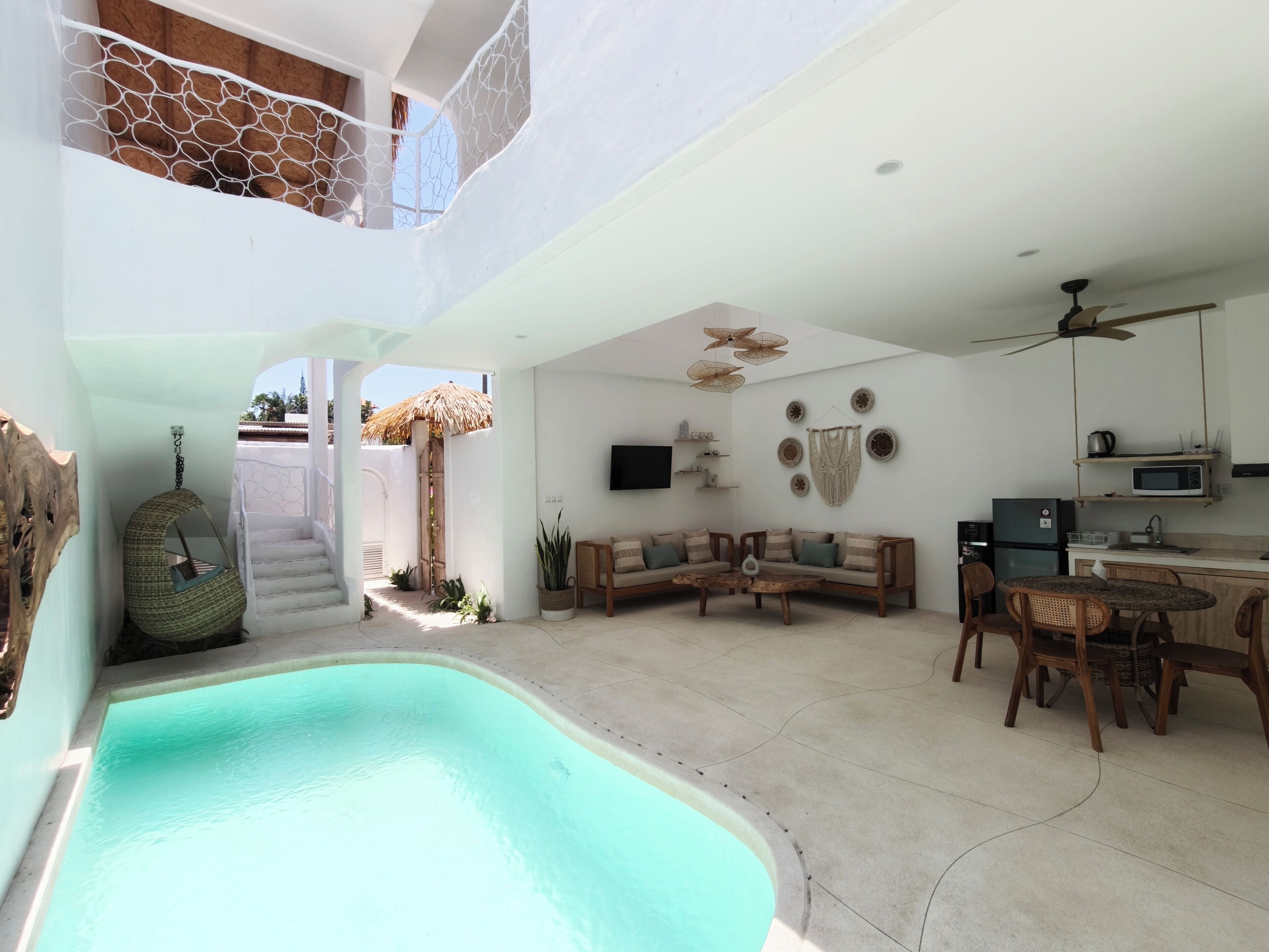 Amplia sala de estar con piscina, comedor y cocina.