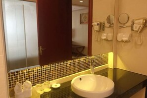 A bathroom with a sink, mirror, and towel rack. - Riyueheng Hotel (Hezhou)