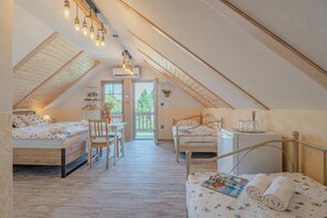 Une chambre mansardée accueillante, avec deux lits, une petite table et une chaise.