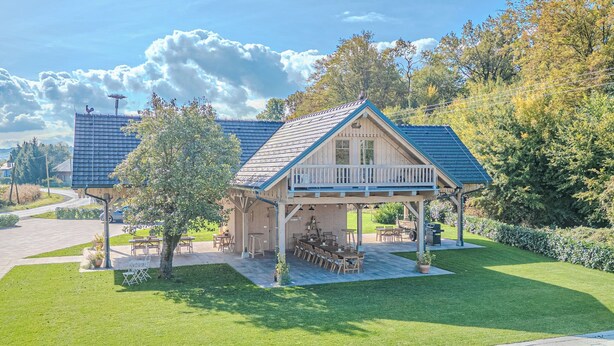 A two-story building with a covered patio area, a swimming pool, and a well-maintained lawn.