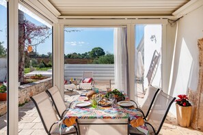An outdoor dining area with a table set for two, surrounded by chairs, with a view of the countryside. - Trullo ConoSolo With Pool, Martina Franca, Italy (Martina Franca)