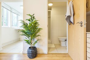 Ein Badezimmer mit Toilette, Dusche und einem Handtuch an der Wand.