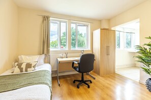 Ein Schlafzimmer mit Bett, Schreibtisch und Kleiderschrank.