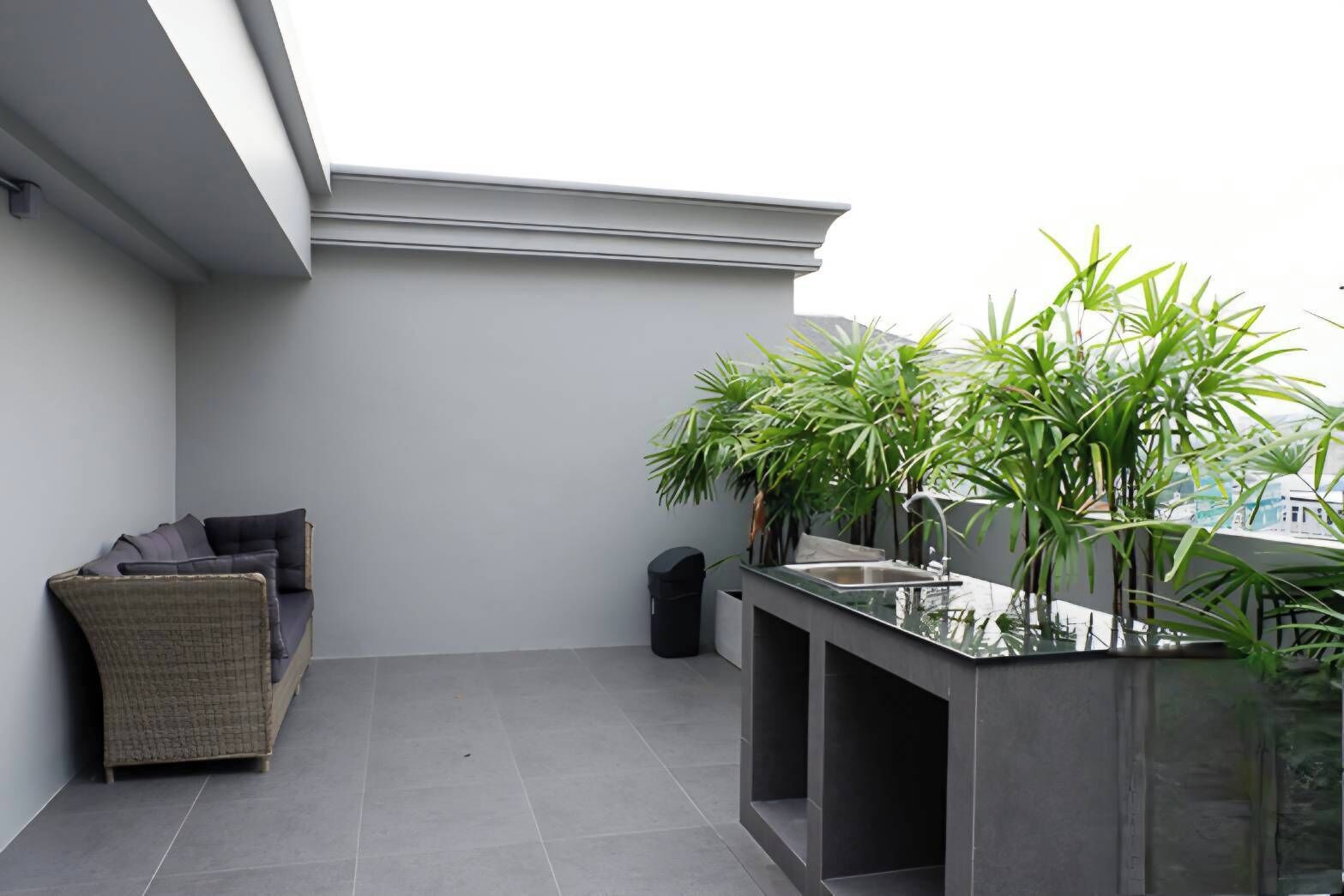 Un balcon avec un canapé, un évier et des plantes en pot.