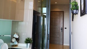 A modern kitchen with a built-in refrigerator, a sink, and a countertop with dishware. - Mayfair Bangkok (Krung Thep Maha Nakhon)