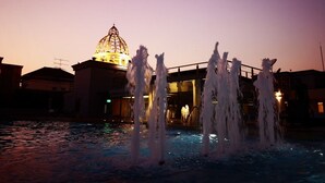 A fountain with multiple water jets in a public square at dusk. - Mayfair Bangkok (Krung Thep Maha Nakhon)