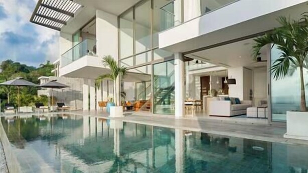 A modern pool area with clear water, a glass-enclosed lounge, and outdoor seating. - Malaiwana - Duplex (B2) by Elite Havens (A. Thalang)
