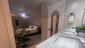 Une salle de bain avec deux lavabos, un miroir et une plante en pot.
