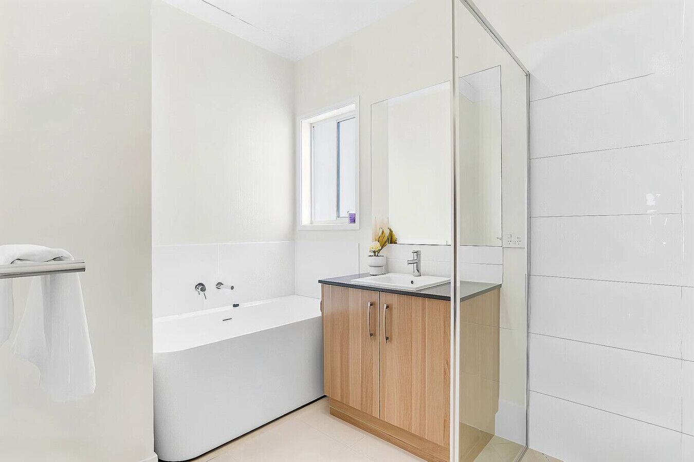 A modern bathroom with a bathtub, a sink, and a mirror.