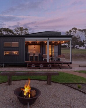 A modern cabin with a covered outdoor seating area, a fire pit, and a view of the surrounding landscape. - Kalimna Tiny ~ Views, Stars & Serenity in Willunga (Willunga)