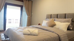 A bedroom with a large bed, beige curtains, and a view through a window. - Ban Slow Life Homestay Koh Libong (Ko Libong)
