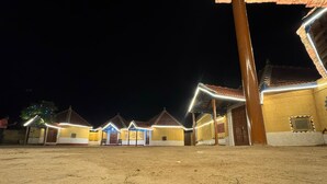 A courtyard with multiple buildings, each with a tiled roof and a central entrance. - Rann Sanji Stay (Bhuj)