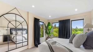 A bedroom with a large bed, a mirror, and a window with curtains. - The Pier Taupo (Taupo)