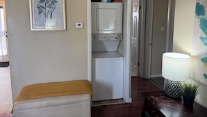 A laundry room with a washing machine, a dryer, and a small cabinet with cleaning supplies.