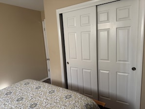 A bedroom with a bed, a wardrobe, and a door.