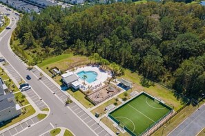 An aerial view of a property with a swimming pool, tennis court, and a road. - Themed 5Bd Home, Movie and Game Room (4726) (Kissimmee)